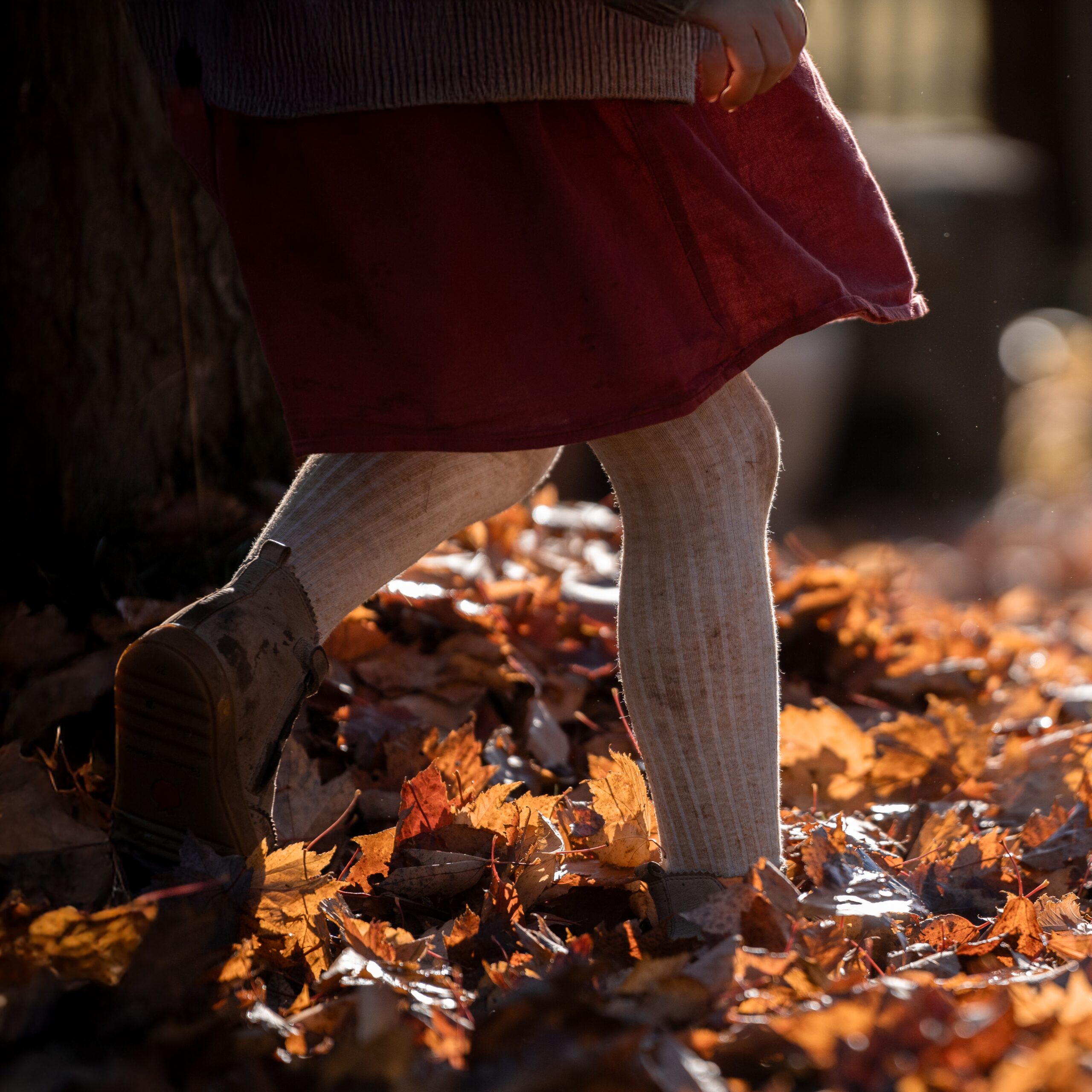 Kind mit Kochmütze rollt Teig mit Nudelholz, natürliche Kinderfotografie in der Küche