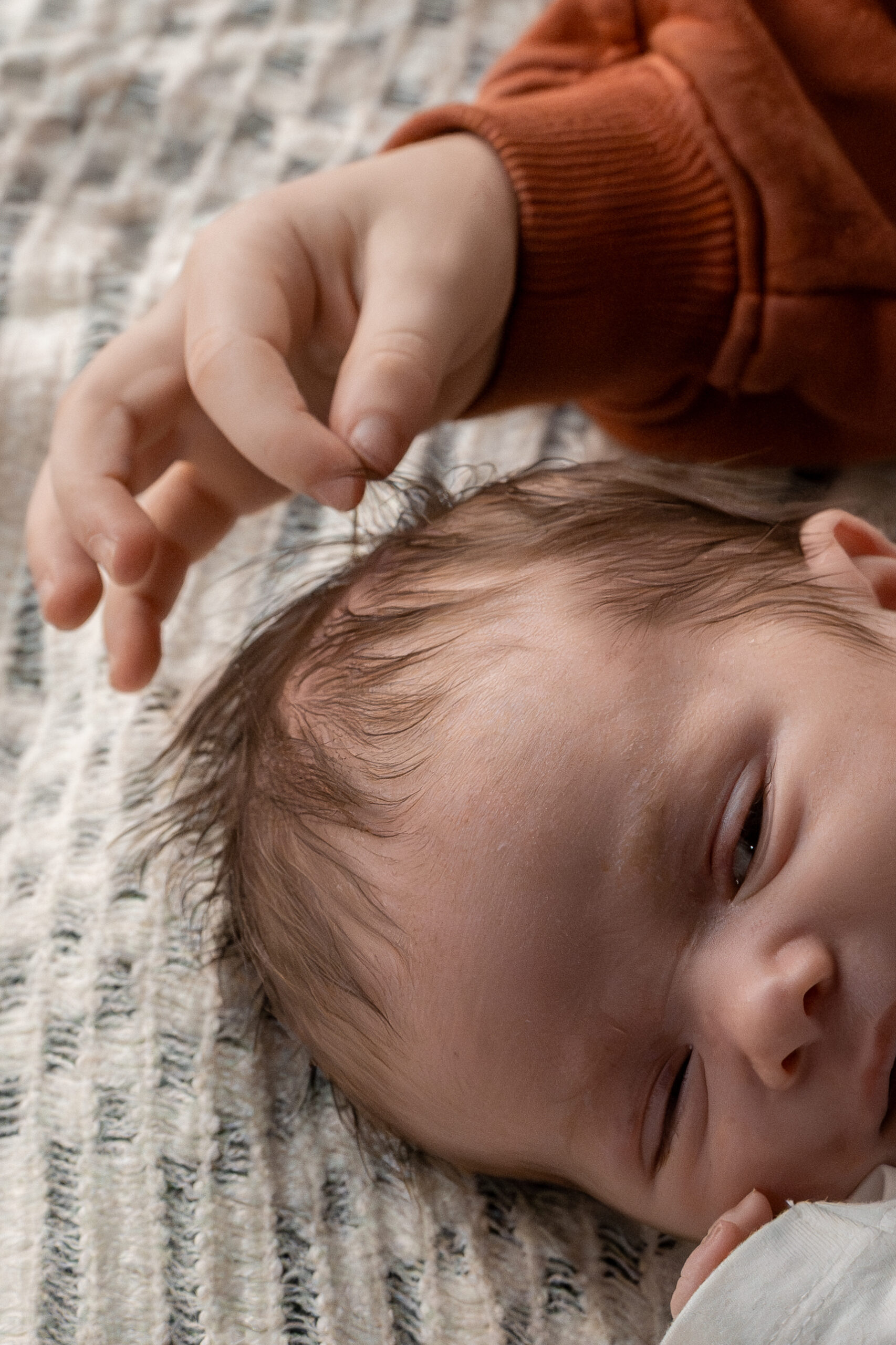 Kind mit Kochmütze rollt Teig mit Nudelholz, natürliche Kinderfotografie in der Küche