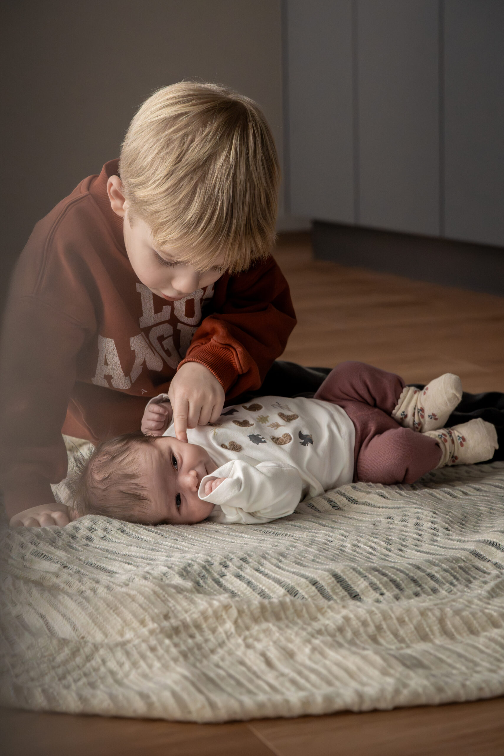 Zwei Kinder lehnen sich aneinander und lachen beim Backen