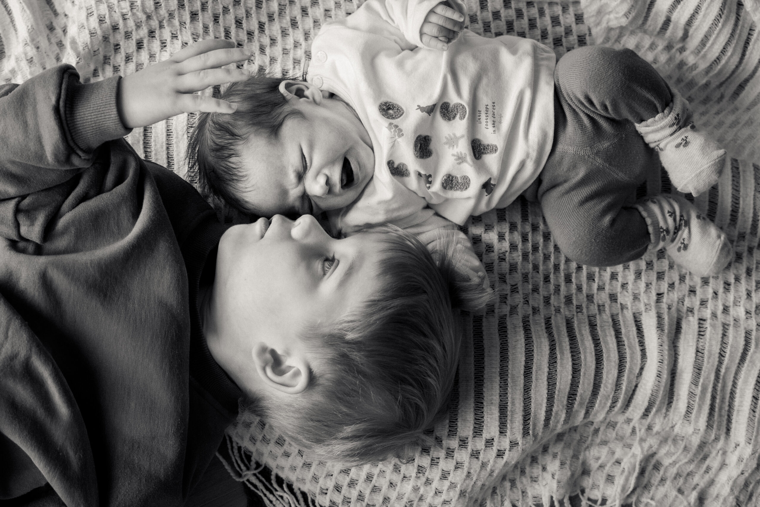 Kleinkind rollt Teig mit Nudelholz, natürliche Kinderfotografie