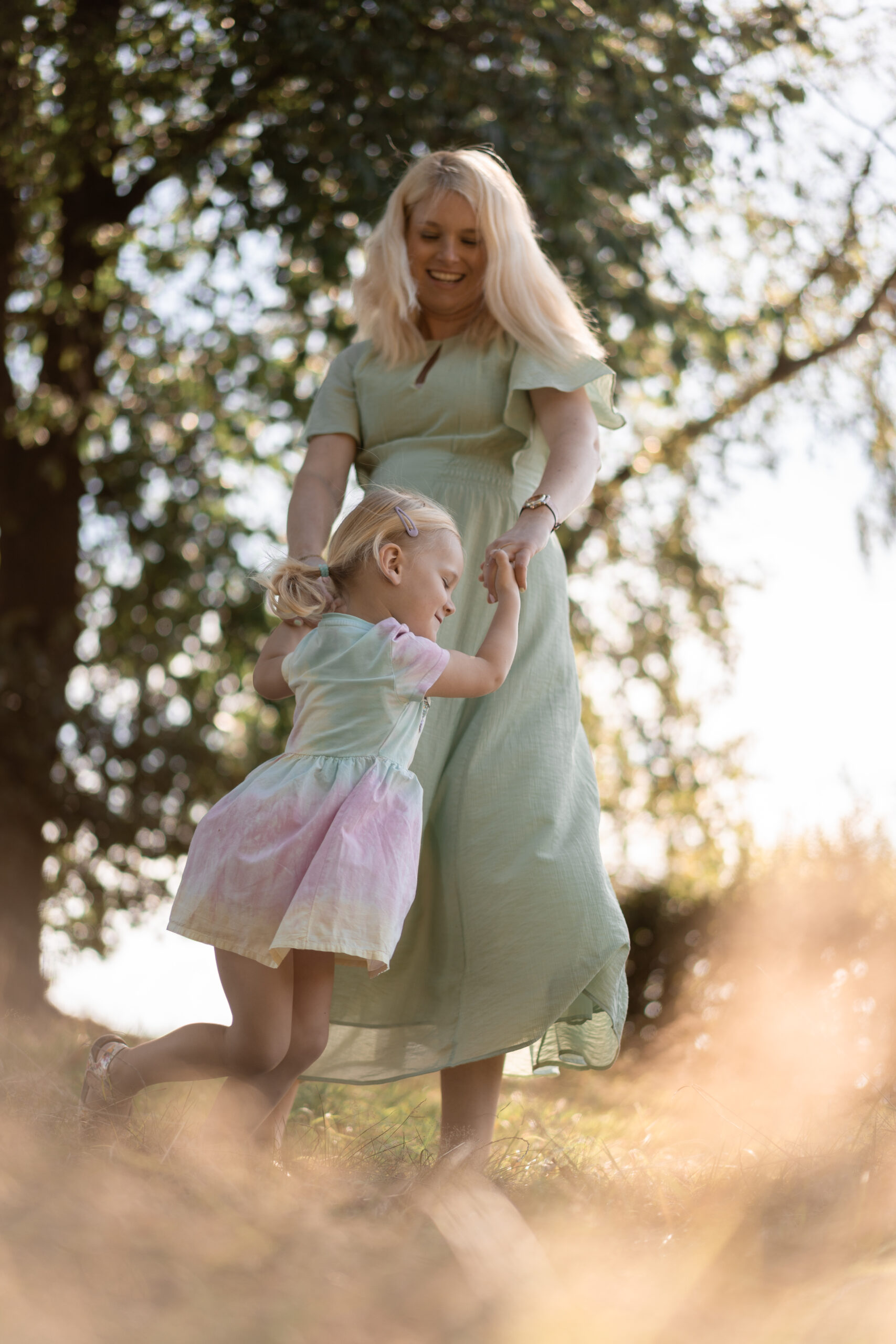 Mama schwingt ihr Kind im Abendlicht, liebevolle Familienfotografie in Melle