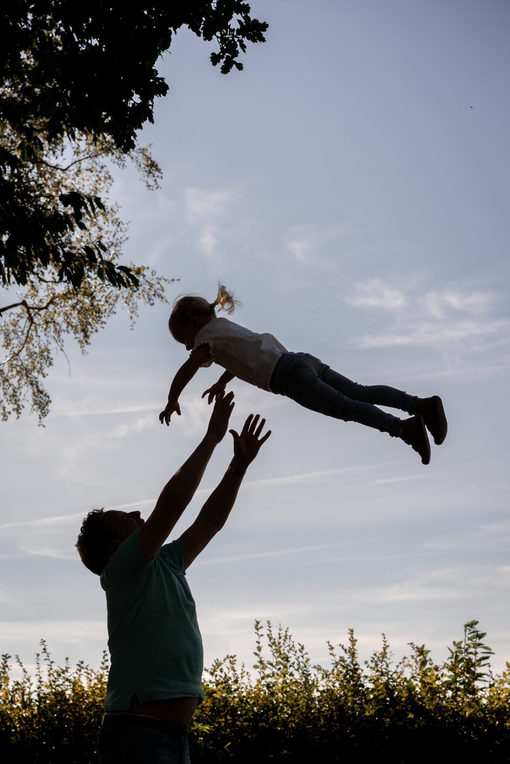 Kind mit Kochmütze rollt Teig mit Nudelholz, natürliche Kinderfotografie in der Küche