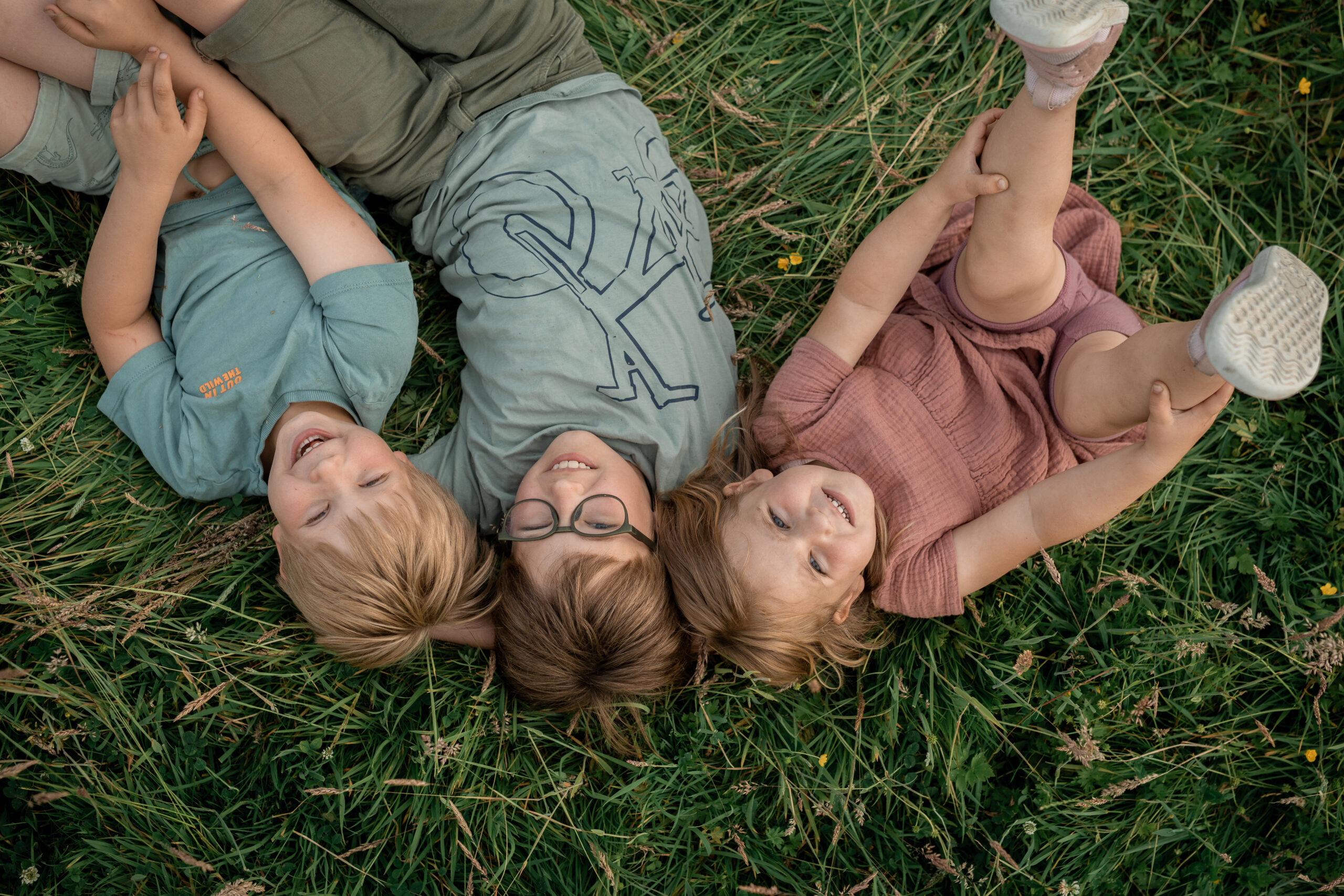 Zwei Kinder sitzen am Tisch beim Plätzchenbacken, liebevolle Kinderfotografie