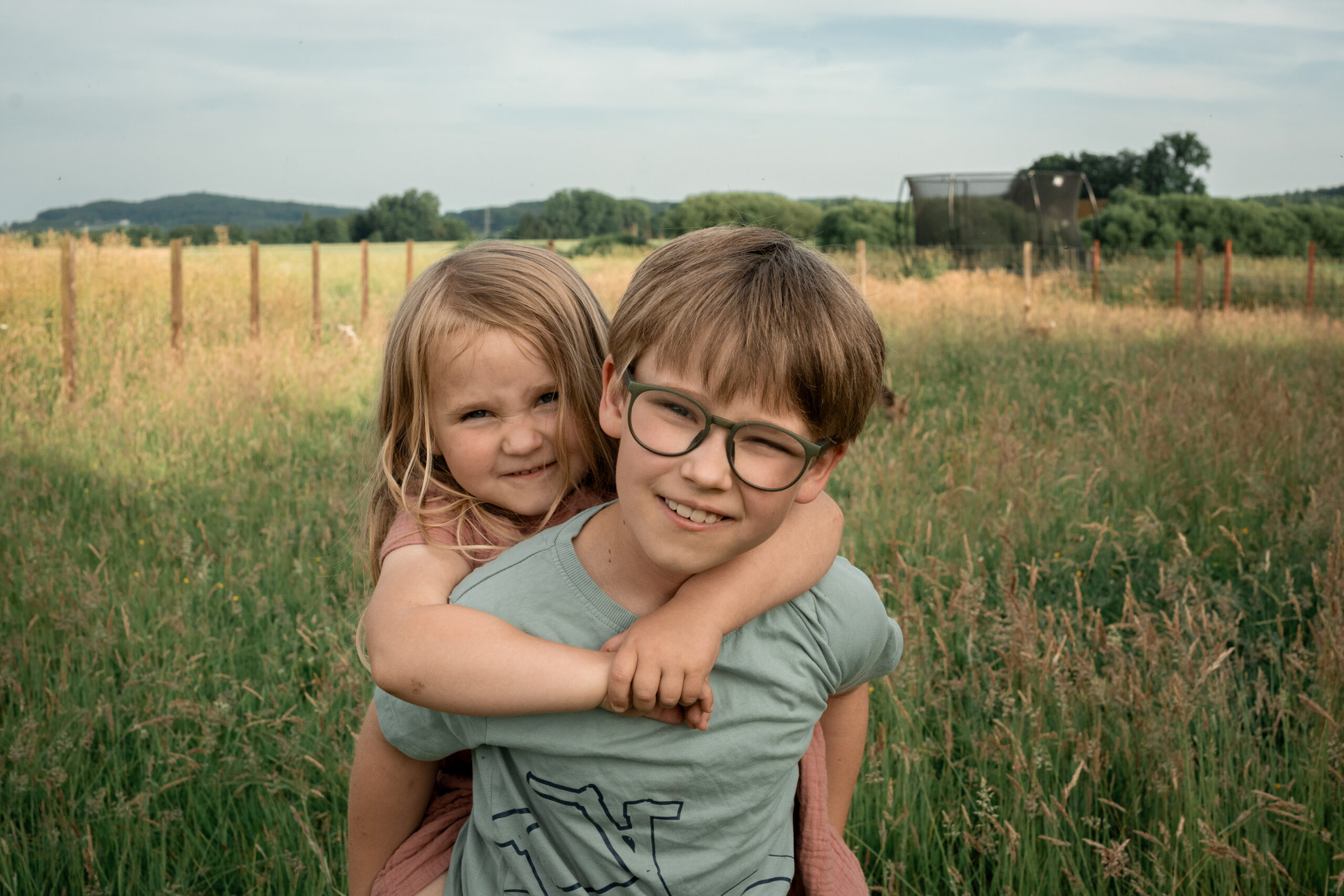 Zwei Kinder sitzen am Tisch beim Plätzchenbacken, liebevolle Kinderfotografie