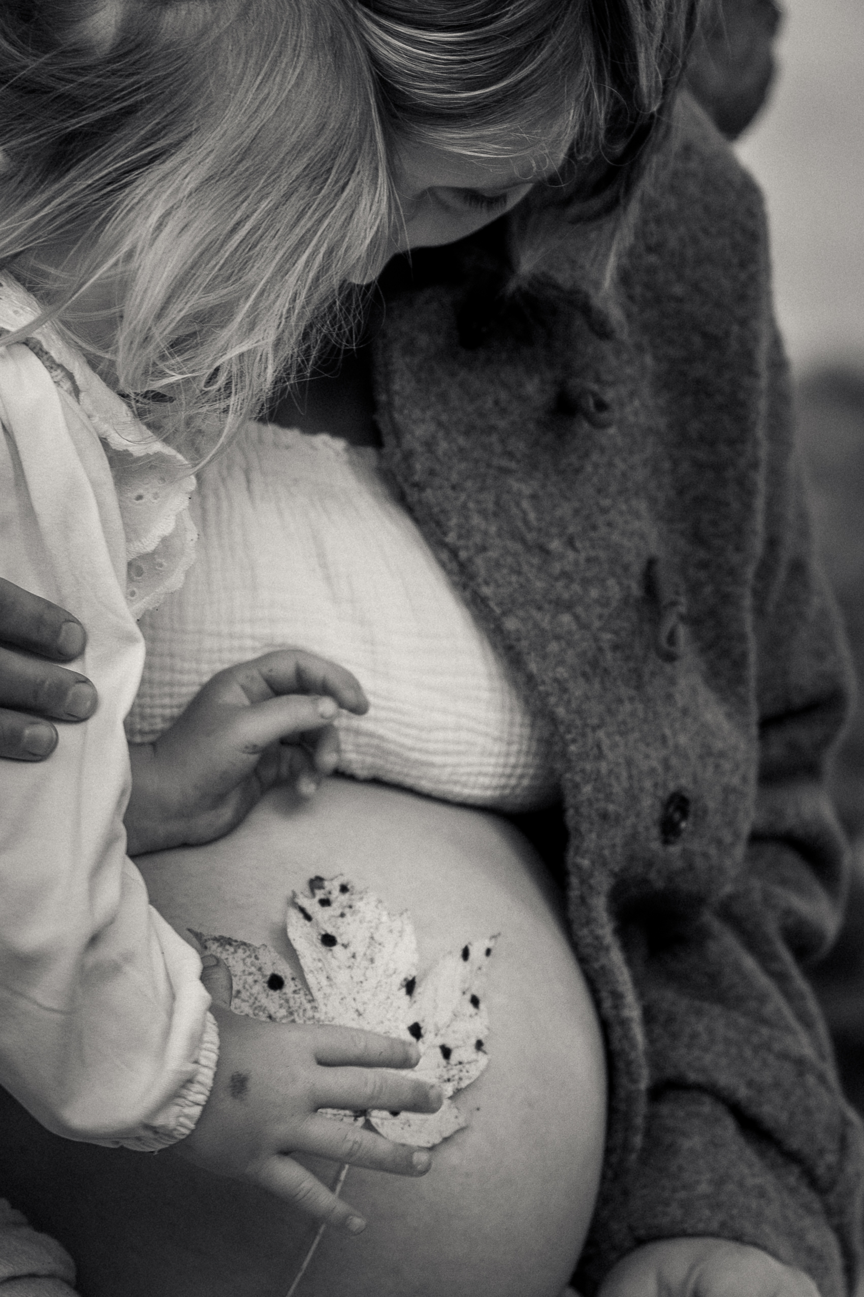 Zwei Kinder sitzen am Tisch beim Plätzchenbacken, liebevolle Kinderfotografie