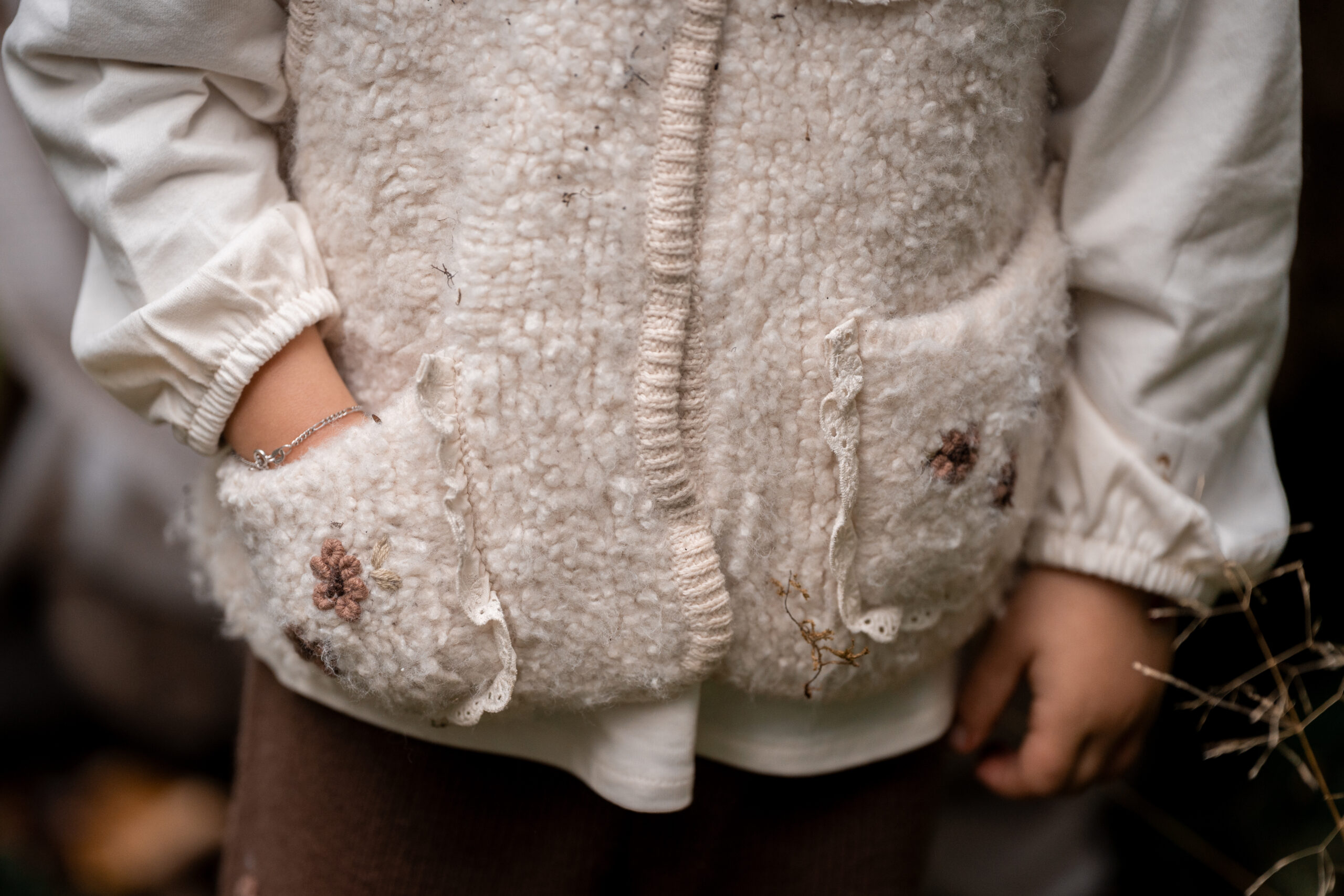 Detailbild von Kinderhand, die sanft auf Babybauch der Mutter liegt