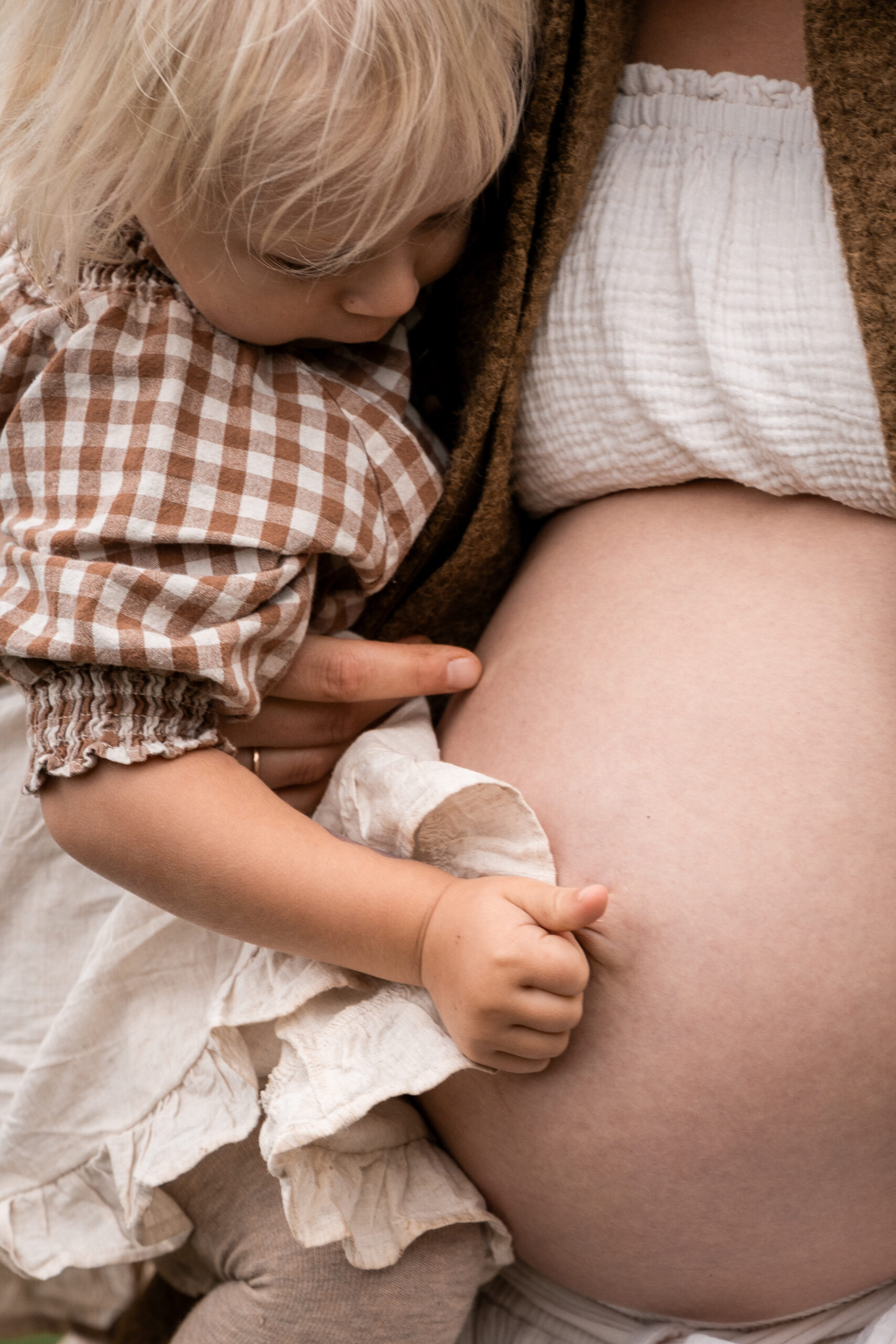 Zwei Kinder sitzen am Tisch beim Plätzchenbacken, liebevolle Kinderfotografie